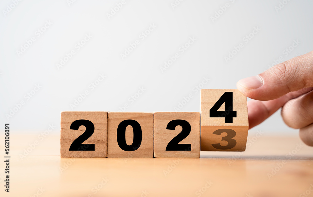 Aufkleber hand flipping wooden block cube change from 2023 to 2024 for preparation new year change and start n