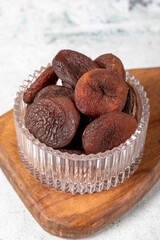 Dried apricots on stone background. Dark dried apricots in a glass bowl. Diet foods. close up