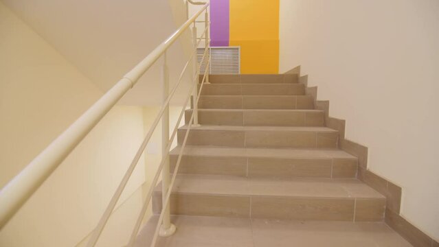 Clean light staircases with railings in hall of contemporary residential building. Empty steps in renovated house