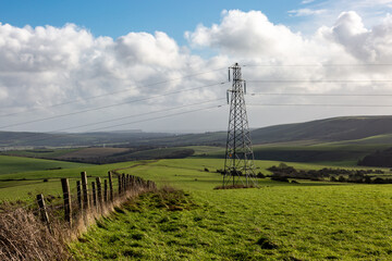 A rural South Downs view with an electricity pylon in the countryside - obrazy, fototapety, plakaty