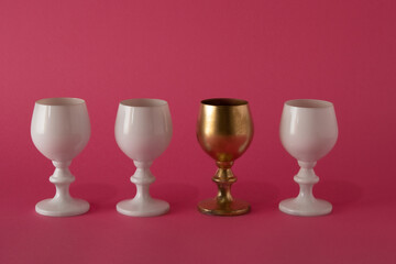 At a party we are all the same even though we are different. white and gold wine glasses on a pink background