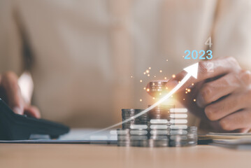 Human hand putting money on a stack of coins,and graphs showing increasing profits and business growth, Concepts of progress in improving financial efficiency and investment