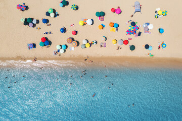 Aerial view of colorful umbrellas on sandy beach, people in blue sea at bright sunny day in summer. Beach, Sardinia, Italy. Tropical landscape with turquoise water. Travel and vacation. Top view - obrazy, fototapety, plakaty