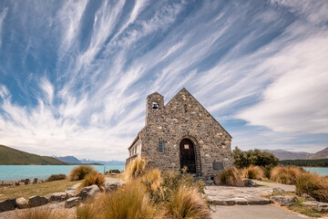 Fototapeta na wymiar Wispy clouds and blue sky behind the Church of the Good Shepherd on the banks of Lake Tekapo in New Zealand