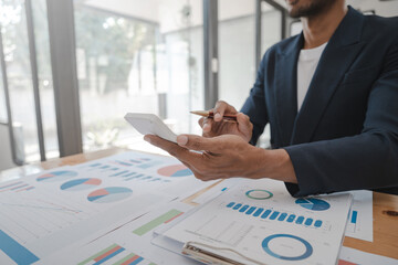 Using calculator, Asia business man working with balance sheet of accounting for calaulating finance, tax, accounting, statistics and analytic research concept