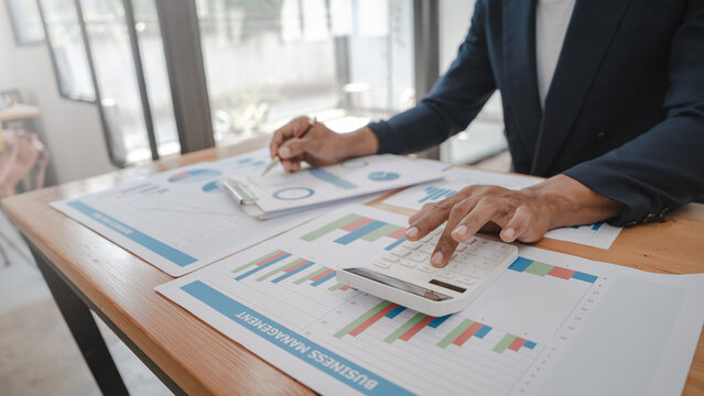 Asia business man working with balance sheet of accounting for calaulating finance, tax, accounting, statistics and analytic research concept