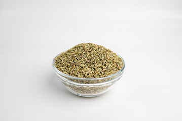 Fennel seeds in a glass dish on a white background 