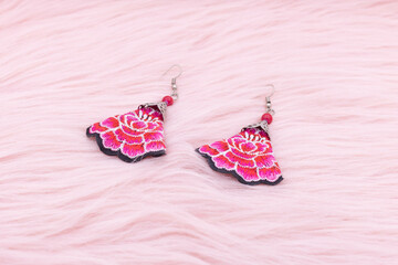 Chinese earrings, Close up of a pair of chinese style earrings on a pink background. Antique...