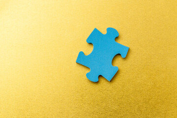 Single blue puzzle piece on a golden background