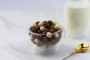 Breakfast cereal close-up. Bowl of corn flakes on a white marble table