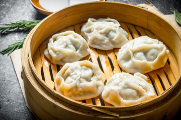 Fresh dumplings of manta with meat in a bamboo steamer.