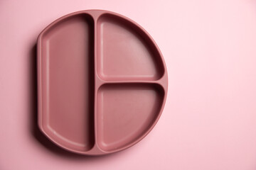 Top view of baby silicon dark pink plate on the pink background. Self feeding concept