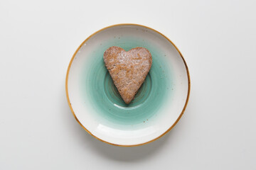 heart shaped cookies on blue plate on white background