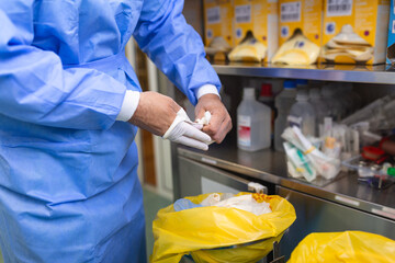 Male surgeon removing surgical gloves in operation theater at hospital