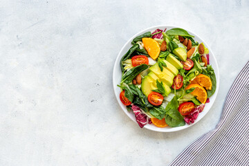 Healthy vegetarian bowl of green salad with avocado and tomatoes
