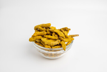 Turmeric , dried turmeric roots , curcuma in a glass dish on a white background