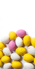 Colorful chocolate Easter eggs on white background with copy space