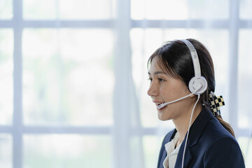 Female customer support telephone operator, beautiful smiling asian woman in office space...