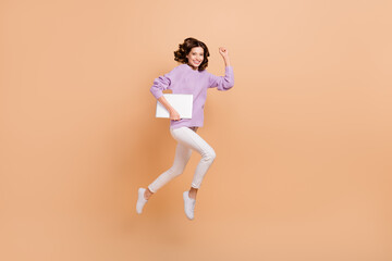 Fototapeta na wymiar Full size photo of pretty adorable woman with curly hairdo wear knit sweater hold laptop hurry work isolated on beige color background