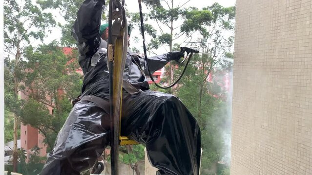 Window Washer Cleaning Building Facade Exterior. Worker Cleaning Building Window. Seen From The Inside Of Apartment