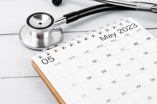 The stethoscope medical and May 2023 desk calendar on wooden background, schedule to check up healthy concepts.