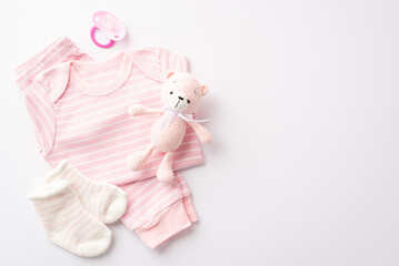 Baby accessories concept. Top view photo of pink shirt pants socks pacifier and knitted teddy bear toy on isolated white background with copyspace
