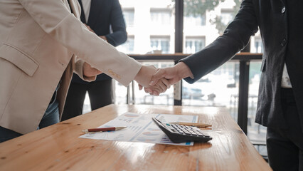 Shaking hands of businessman and Certified Public Accountant (CPA) auditor providing accounting and auditing services in the same company and stock market chart data and anti bribery of accounting