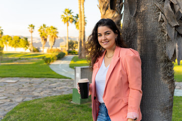 Well-dressed young girl, holding her glass of coffee.