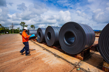 Engineer one worker man inspection on hole rolls of metal carbon steel sheets outside the factory