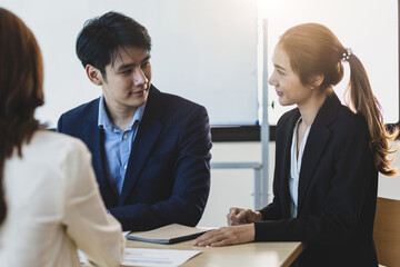 Group office colleagues having casual discussion during meeting in conference room.