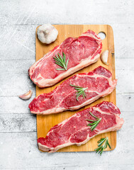 Raw beef steaks with spices and herbs.