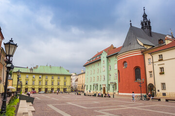 Small market square with church and shops in Krakow, Poland