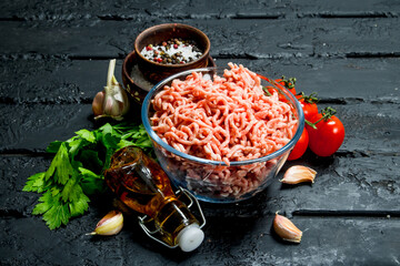 Raw minced meat in a bowl with spices and herbs.