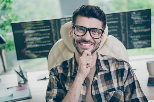 Photo of smart clever coder dressed eyewear hand arm chin working modern gadget indoors workplace workstation loft