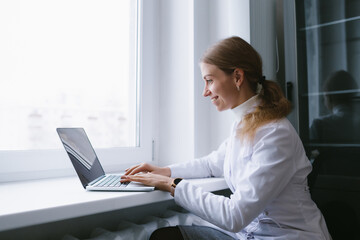Young female doctor talking to patient online from medical office.
