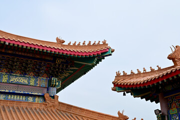 BANGKOK, THAILAND - January 16, 2023 : Part of the Roof of chinese temple in Thailand. Traditional Chinese style pattern on the roof of a temple with Blue Sky Background.
