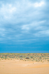 Bright blue cloudy sky over the yellow desert of Kyzylkum Kazakhstan