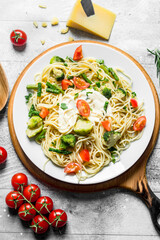 Pasta with vegetables and tomatoes on a branch.
