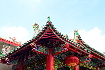 BANGKOK, THAILAND - January 16, 2023 : Part of the Roof of chinese temple in Thailand. Traditional Chinese style pattern on the roof of a temple with Blue Sky Background.
