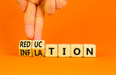 Inflation or reduction symbol. Concept word Inflation Reduction on wooden cubes. Businessman hand. Beautiful orange table orange background. Business inflation or reduction concept. Copy space.