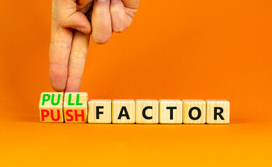 Pull or push factor symbol. Concept word Pull factor and Push factor on wooden cubes. Beautiful orange table orange background. Businessman hand. Business pull or push factor concept. Copy space.