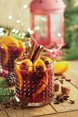 Christmas hot mulled wine. Glasses of mulled wine with aromatic spices cinnamon, anise, sugar and fir tree branches with bokeh and decorations. Traditional Xmas festive drink. Winter Christmas drink.