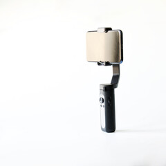 Modern smartphone and selfie stick - a three-axis stabilizer for photo and video shooting on mobile phone. Gadgets for blogging, streaming and video conferencing. Copy space. Selective focus.