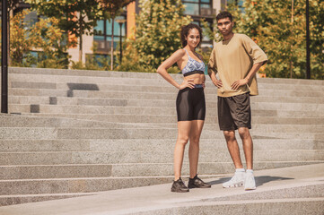 Sporty couple posing for the camera outside