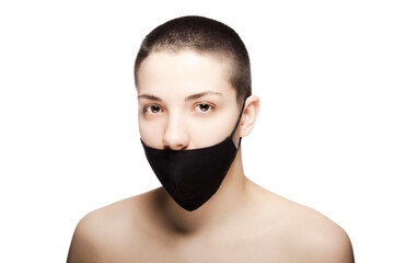 Cute girl with very short hair wearing black protective face mask. Studio portrait isolated on white background..