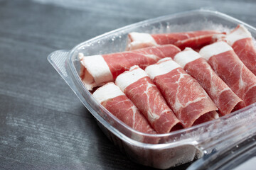 A view of a plastic container filled with semi-frozen slices of Australia New Zealand lamb shoulder.