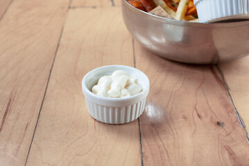 A view of a condiment cup of mayonnaise.