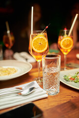Syringe-cocktail Aperol. Two glasses of champagne, cocktails or wine wafting up to the party celebration theme 