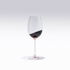 A glass of red wine stands straight and the wine in it is tilted at an angle. Surreal drinking culture, party or celebration composition.