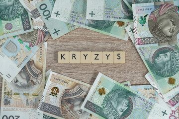 Kryzys in Polish language means crisis. Inflation and rising prices in Poland and rest of Europe. Flat lay concept with Polish złoty money, PLN zloty banknotes.